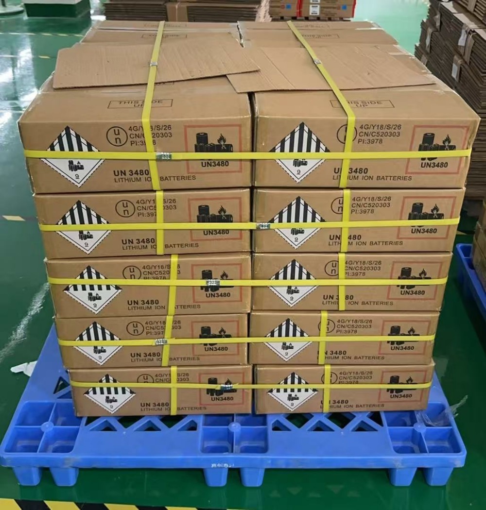托盘上整齐堆码的UN 3480锂离子电池危险品纸箱，带9类危险品标签